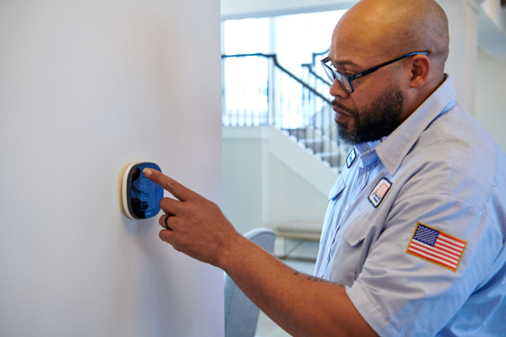 AC tech installing a thermostat