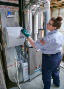 HVAC tech inspecting furnace