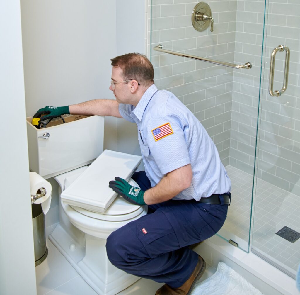 technician inspecting toilet