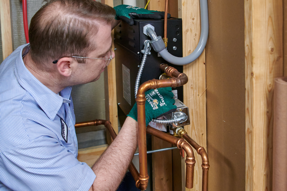 plumbing expert inspecting sump pump plumbing