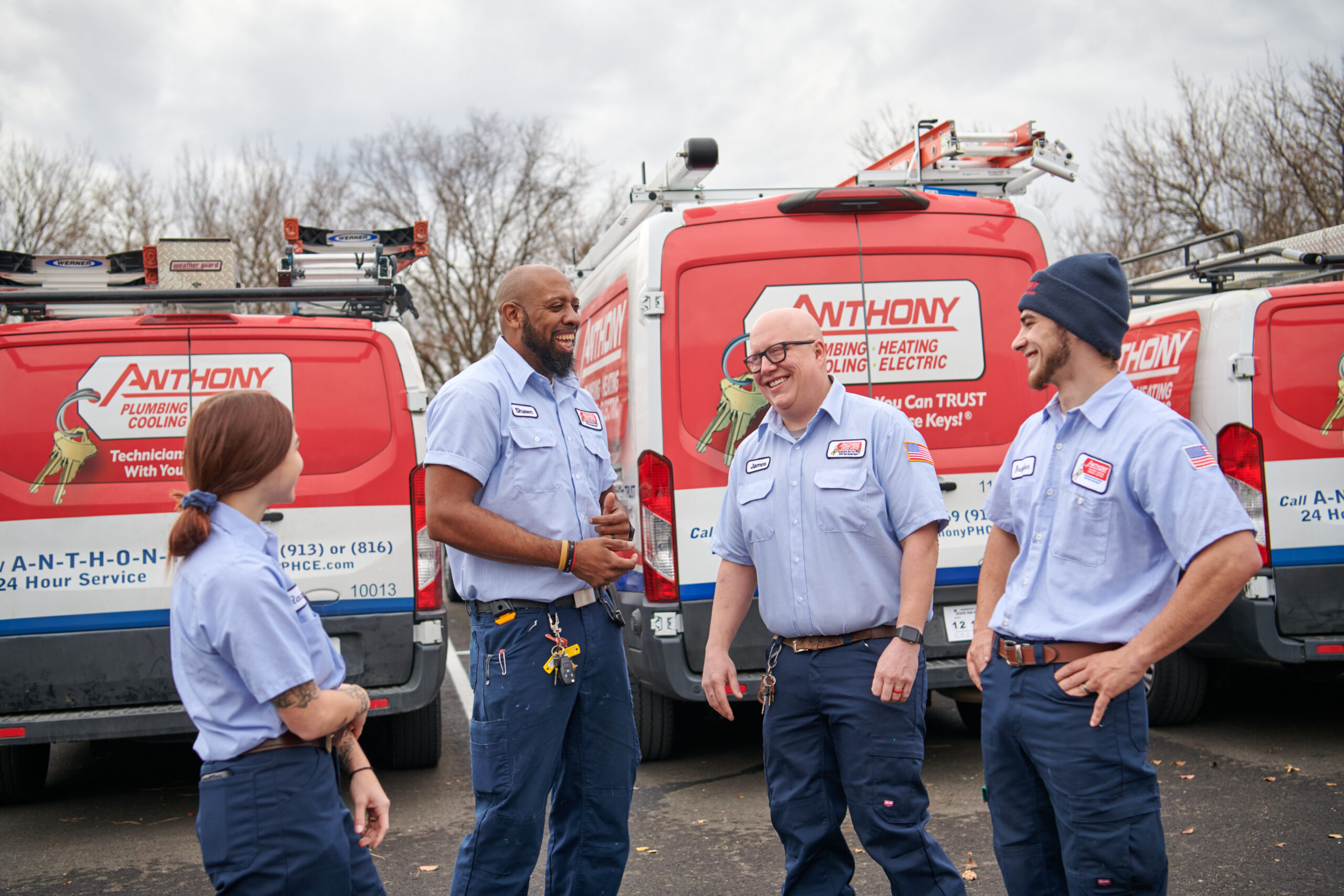 Anthony electricians standing behind vans