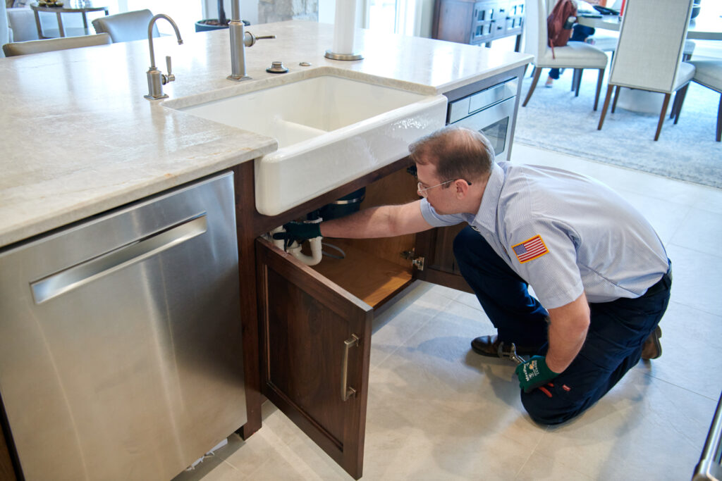 plumber working on kitchen sink drain