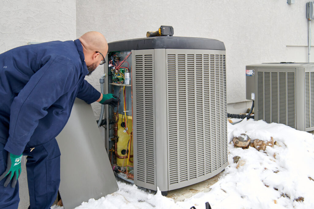 HVAC tech inspecting AC unit