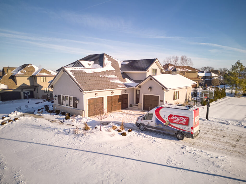 house covered in snow with Anthony van in front